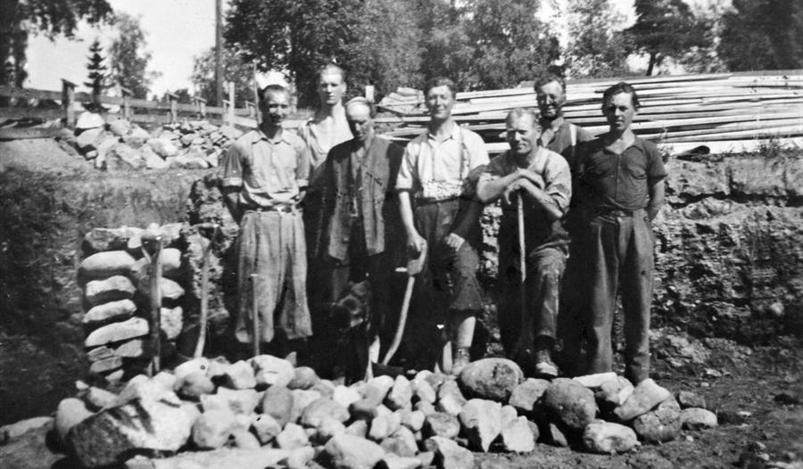 menn med hakker som står foran steinhaug