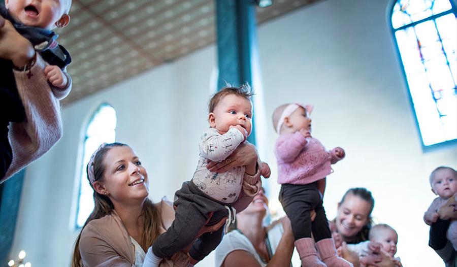 Babyer og foresatte i kirkerommet