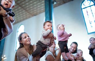 Babyer og foresatte i kirkerommet